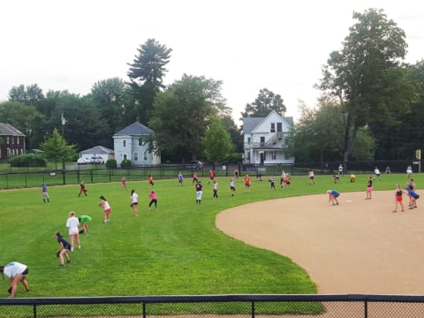 Softball campers lined up in the outfield for drill