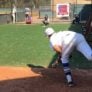 Baseball pitcher follows through on throw to catcher in bullpen