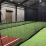 Indoor batting cage enclosed by black netting