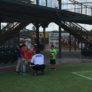 Coach squats to speak with group of campers at Scrap Yard Sports baseball fields