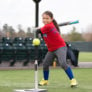 Nike softball camper ready to swing at softball on tee