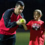 Nike Softball Camper gets finger position adjusted by coach