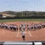 Softball athletes line 1st and 3rd baseline for end of camp ceremony