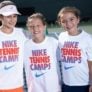 Tennis girls smiling in front of net